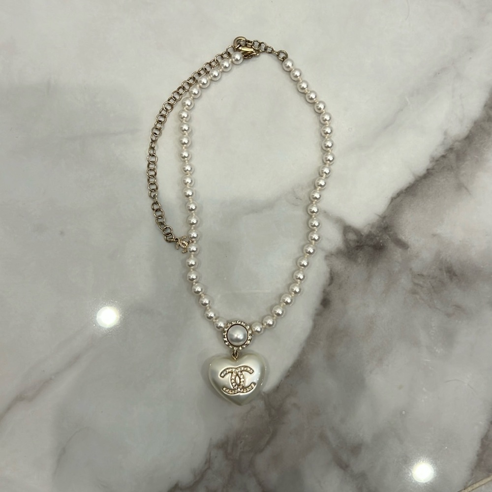 Authentic Chanel pearl, crystal, CC, heart necklace and pearly, white, and gold.